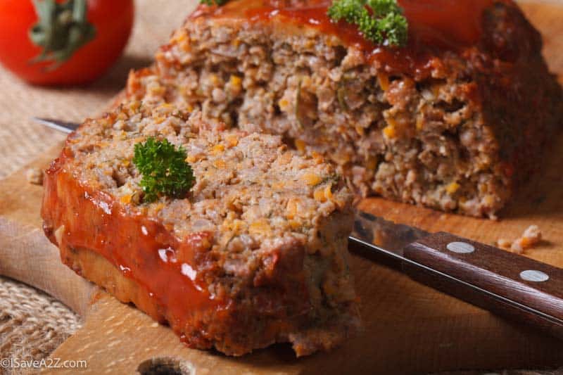 meat loaf with ketchup and vegetables close-up on chopping board. horizontal