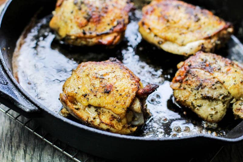 Keto Lemon Garlic Chicken Recipe Golden chicken in a cast iron pan.