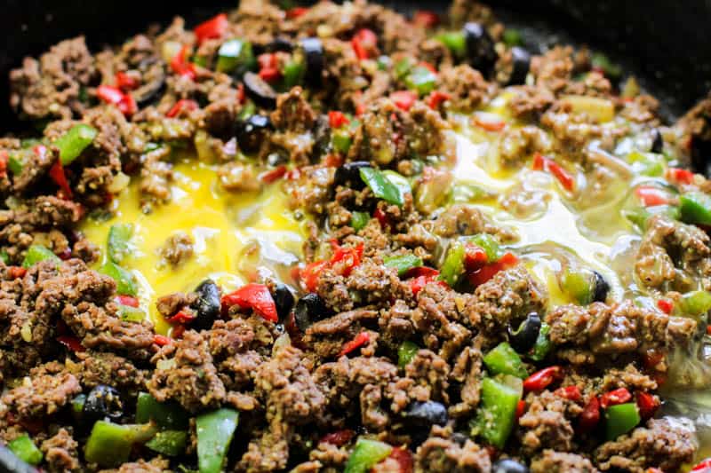 Ground beef with egg in cast iron pan.