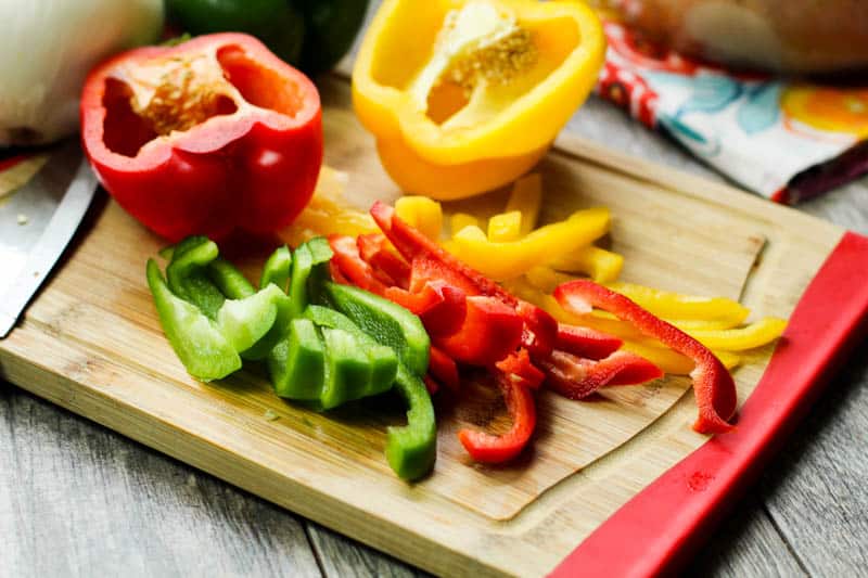 red yellow and green peppers on a cutting board
