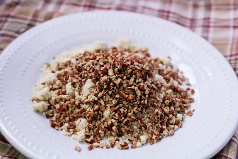 Crushed pecans over almond flour on a plate