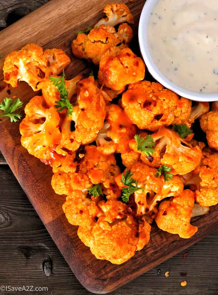 Cauliflower buffalo wings. Top view table scene against a wood background with copy space. Healthy eating, plant based meat substitute concept.