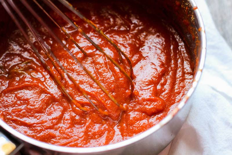 whisking homemade bbq sauce in pan 