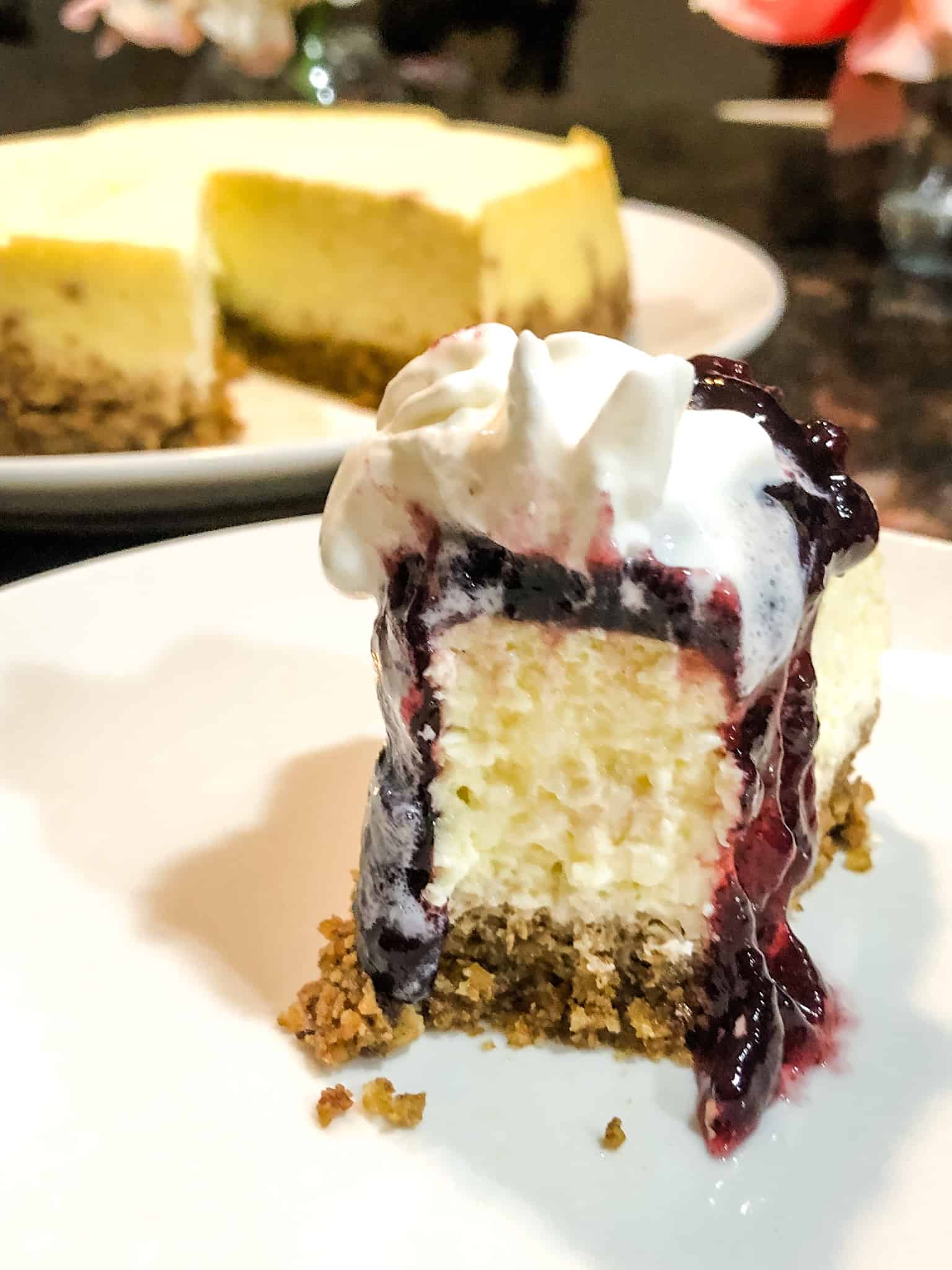 Keto Vanilla Cheesecake served with blueberry sauce and whipped cream