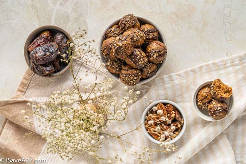 overhead photo of pecan pie truffles in a white bowl with dates and pecans in a bowl nearby