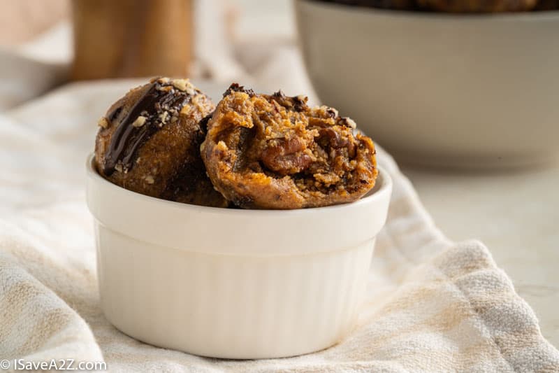 side photo of a small bowl with pecan pie truffles for the holidays in a white bowl with a bite eaten